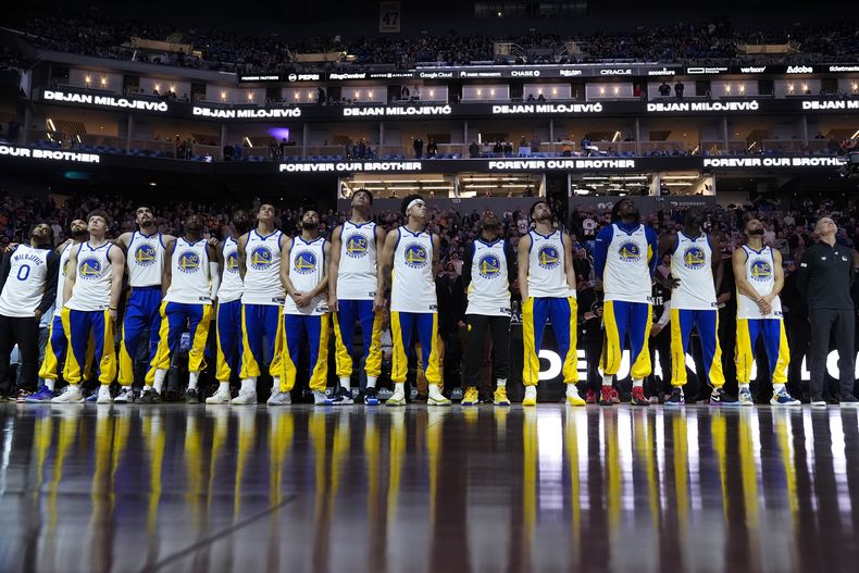 Los Warriors de Golden State observan un homenaje en video para Dejan Milojevic, el entrenador asistente recientemente fallecido, antes del partido del miércoles 24 de enero ante los Hawks de Atlanta (AP Foto/Godofredo A. Vásquez)