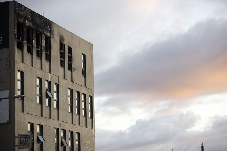 La luz de la mañana ilumina el lugar donde se produjo un incendio en el hostal Loafers Lodge en Wellington, Nueva Zelanda. La policía de Nueva Zelanda cree que el incendio que mató al menos a seis personas en un hostal de Wellington fue provocado y ha iniciado una pesquisa de homicidio, según las autoridades. (George Heard/New Zealand Herald via AP)
