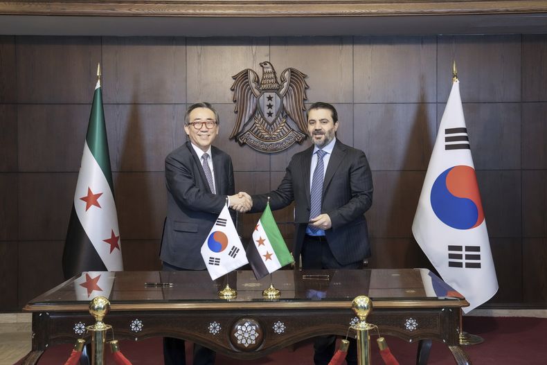 En esta foto suministrada por el Ministerio de Asuntos Exteriores de Corea del Sur, el ministro surcoreano de Asuntos Exteriores, Cho Tae-yul (izquierda), estrecha la mano del ministro sirio de Asuntos Exteriores, Asaad al-Shaibani, tras firmar una declaración conjunta sobre el establecimiento de lazos diplomáticos entre ambos países en Damasco, Siria, el jueves 10 de abril de 2025. (Ministerio de Asuntos Exteriores de Corea del Sur vía AP)
