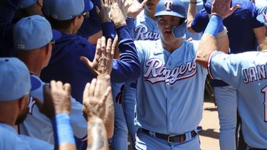 Josh Jung, de los Rangers de Texas, es felicitado en el dugout después de conectar un grand slam en contra de los Yanquis de Nueva York en la primera entrada durante el juego de béisbol el domingo 30 de abril de 2023, en Arlington, Texas. (AP Foto/Richard W. Rodriguez)