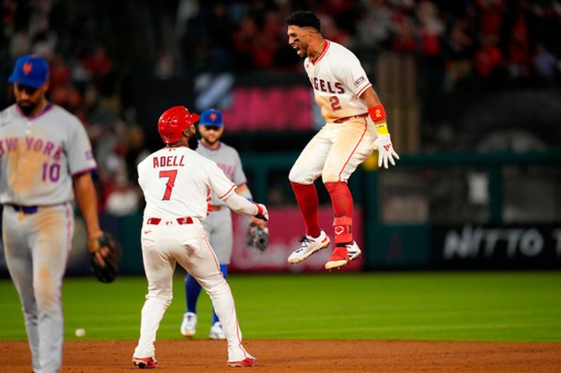 Oswald Peraza, de los Angelinos de Los Ángeles (derecha), celebra su sencillo de la victoria con Jo Adell (centro), mientras el segunda base de los Mets de Nueva York, Marcus Semien, sale del campo en la décima entrada de un partido de béisbol el sábado 2 de mayo de 2026, en Anaheim, California. (Foto AP/Mark J. Terrill)
