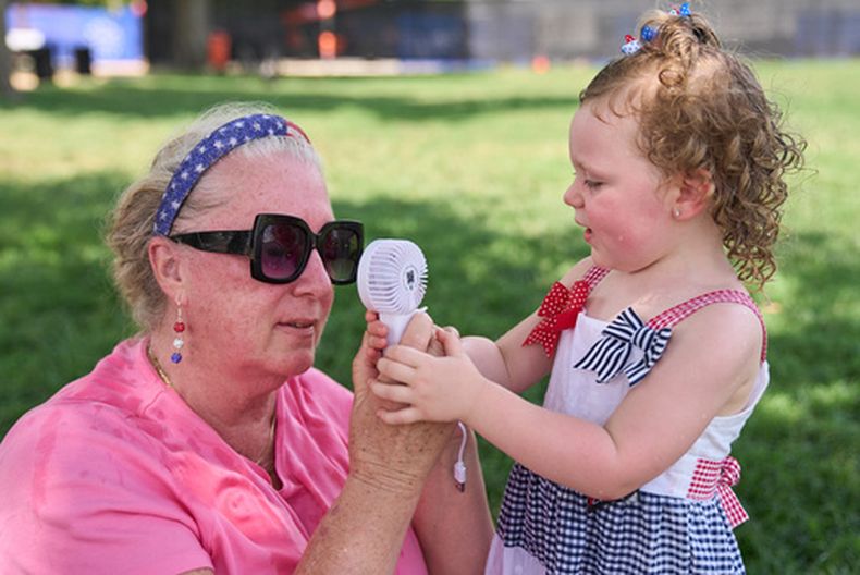Una mujer y su nieta con un pequeño ventilador portátil en el National Mall de Washington, el 1 de julio del 2026. (AP foto/Jacquelyn Martin)