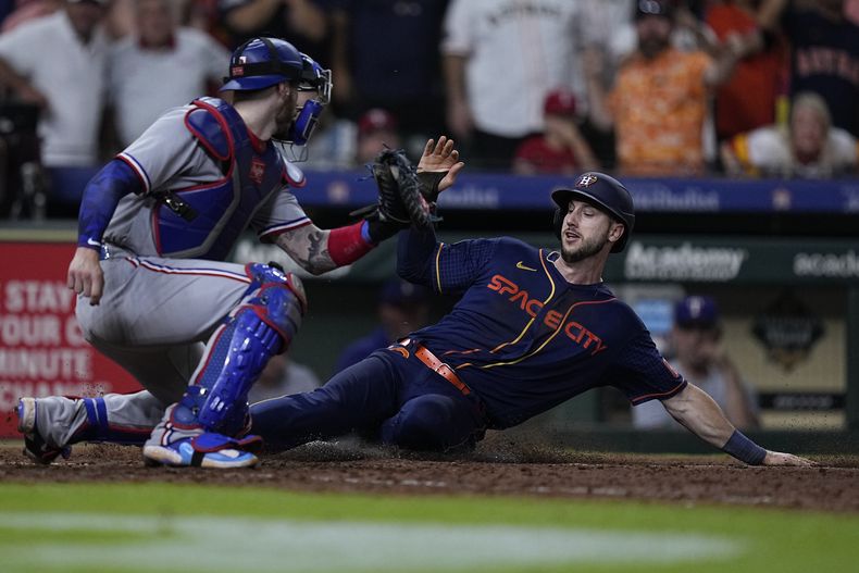 Kyle Tucker de los Astros de Houston anota la carrera de la victoria superando al catcher de los Rangers de Texas Jonah Heim tras el sencillo del dominicano Yainer Díaz en el encuentro del lunes 24 de junio del 2023. (AP Foto/Kevin M. Cox)