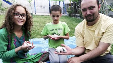 Esta foto familiar muestra a Ryan Corbett sosteniendo conejos con su hija Miriam y su hijo Caleb en Kabul, Afganistán, en 2020. (Anna Corbett via AP)