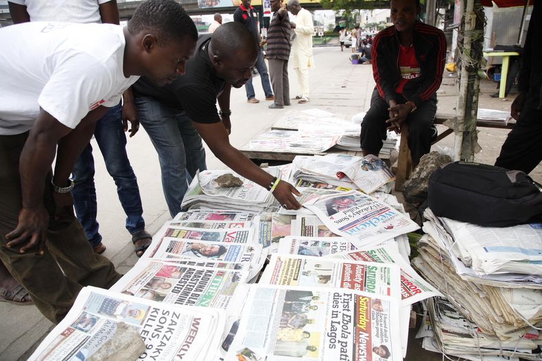 Personas leen en una calle en Lagos, Nigeria, diversos diarios en los que se anuncia el s&aacute;bado 26 de julio de 2014 la muerte de una persona liberiana en el pa&iacute;s a causa del virus del Ebola. Debido a este virus han muerto m&aacute;s de 660 pe