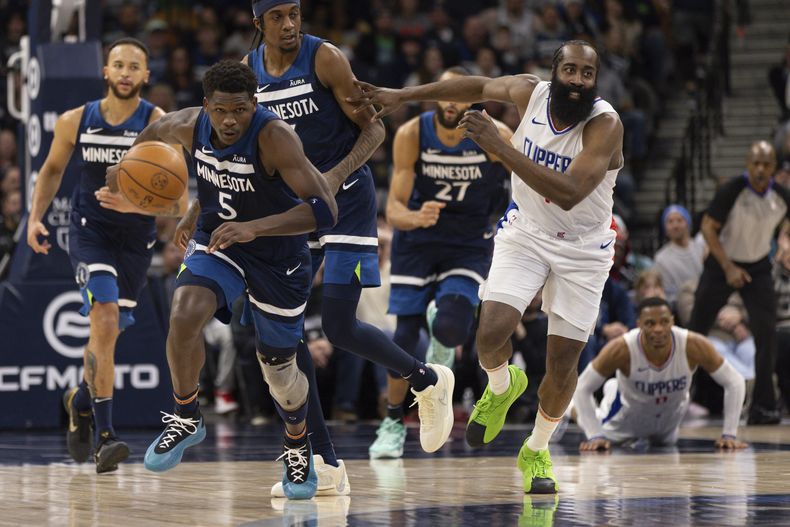 Anthony Edwards (5), de los Timberwolves de Minnesota, y James Harden, derecha, de los Clippers de Los Ángeles, corren por un balón durante la segunda mitad del juego de baloncesto de la NBA, el domingo 14 de enero de 2024, en Minneapolis. (AP Foto/Bailey Hillesheim)