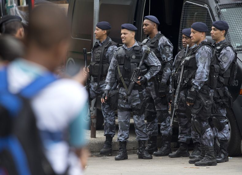 Polic&iacute;as vigilan la favela Rocinha, la m&aacute;s grande de R&iacute;o de Janeiro, Brasil, el lunes 17 de febrero de 2014. Las autoridades ingresaron al vecindario despu&eacute;s de un fin de semana de tiroteos. (Foto AP/Silvia Izquierdo)