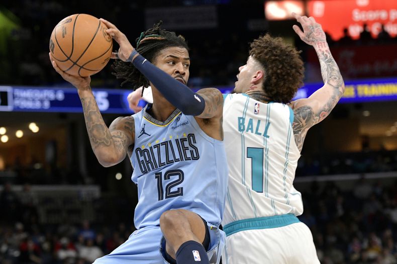 Ja Morant (12), de los Grizzlies de Memphis, maneja el balón cerca de LaMelo Ball (1), de los Hornets de Charlotte, en la primera mitad del juego de baloncesto de la NBA, el miércoles 22 de enero de 2025, en Memphis, Tennessee. (AP Foto/Brandon Dill)