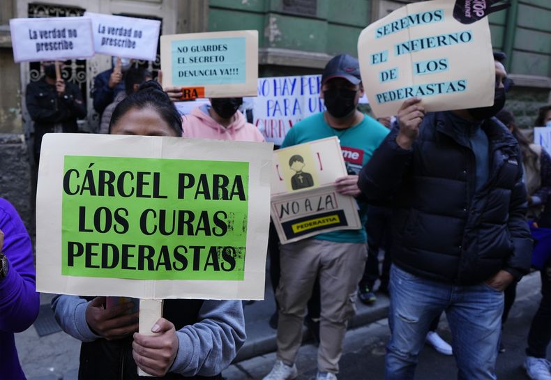 Las personas protestan con carteles que dicen Cárcel para los curas pederastas, entre otros, frente a la oficina del Arzobispado de Bolivia en La Paz, Bolivia, el viernes 19 de mayo de 2023. Milton Murillo, un sacerdote boliviano, ha sido detenido bajo sospecha de abusar de los seminaristas hace una década, poco después de que se conociera la noticia de lo que ha resultado ser el mayor escándalo de pedofilia en la historia del país andino, en el que está involucrado un difunto sacerdote jesuita. (Foto AP/Juan Karita)