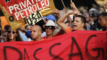 americateve | Manifestantes gritan consignas durante una protesta contra el incremento a la tarifa de autobuses en R&iacute;o de Janeiro, Brasil, el jueves 13 de febrero de 2014. (Foto AP/Silvia Izquierdo)