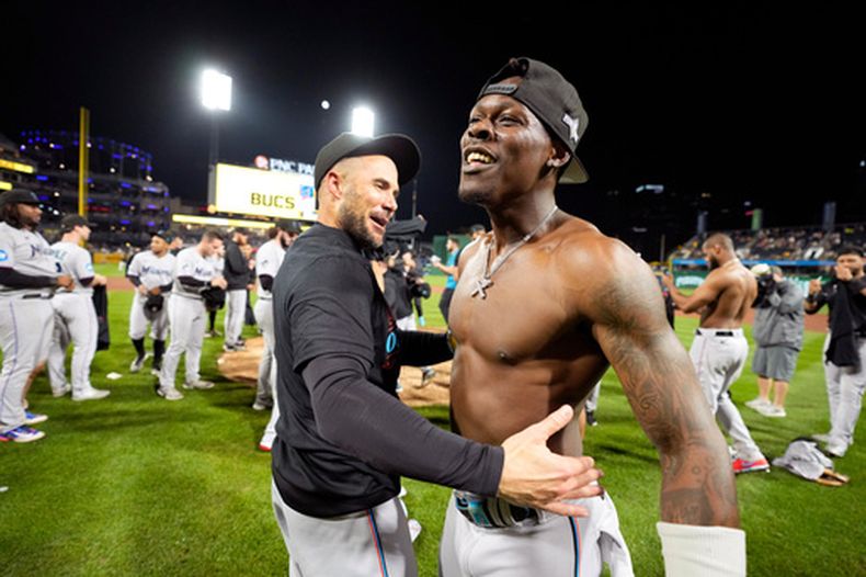 ARCHIVO - Jazz Chisholm Jr. (derecha) de los Marlins de Miami celebra con el mánager Skip Schumaker tras asegurar el boleto a los playoffs de MLB tras vencer a los Piratas de Pittsburgh, el 30 de septiembre de 2023, en Pittsburgh. (AP Foto/Gene J. Puskar)