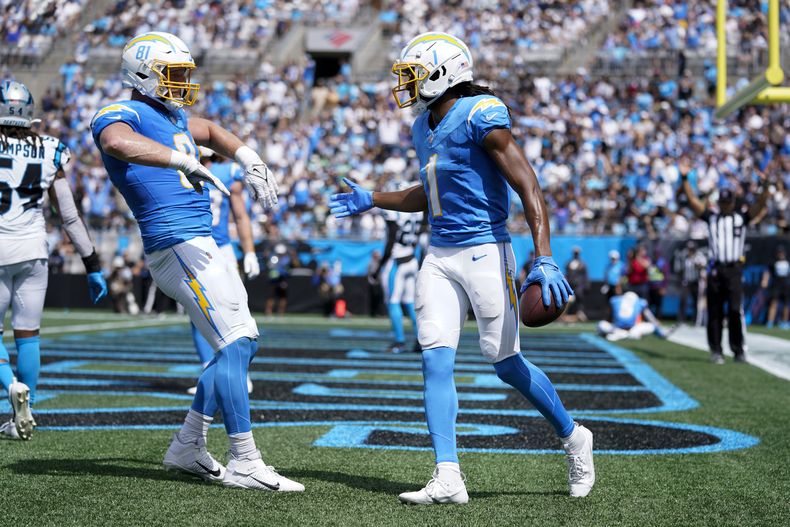 El wide receiver de los Chargers de Los Ángeles, Quentin Johnston, celebra con el tight end Will Dissly después de anotar durante la primera mitad contra los Panthers de Carolina el domingo 15 de septiembre de 2024, en Charlotte, Carolina del Norte (AP Foto/Erik Verduzco)