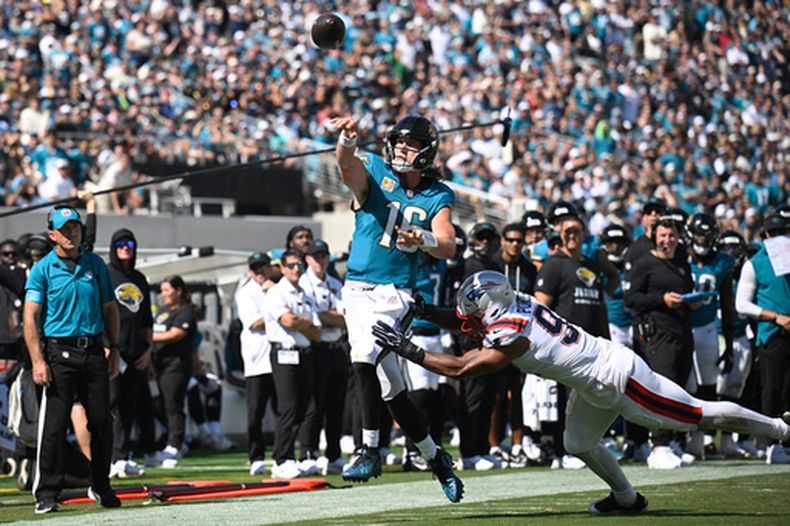 El quarterback de los Jaguars de Jacksonville Trevor Lawrence lanza el balón mientras lo intenta derribar el linebacker de los Patriots de Nueva Inglaterra Elijah Ponder en el encuentro del domingo 27 de septiembre del 2026. (AP Foto/Phelan M. Ebenhack)