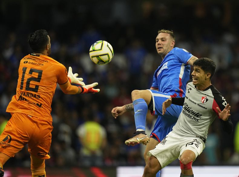 El colombiano Camilo Vargas, arquero de Cruz Azul, busca un balón frente a su compañero Carlos Rotondi y a Diego Barbosa, del Atlas, el sábado 6 de mayo de 2023, en el torneo Clausura mexicano (AP Foto/Fernando Llano)