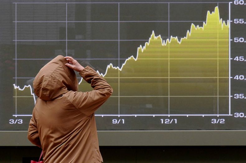 Una persona mira una pantalla con una gráfica del índice bursátil japonés Nikkei en una correduría en Tokio, el lunes 23 de marzo de 2026. (AP Foto/Eugene Hoshiko)