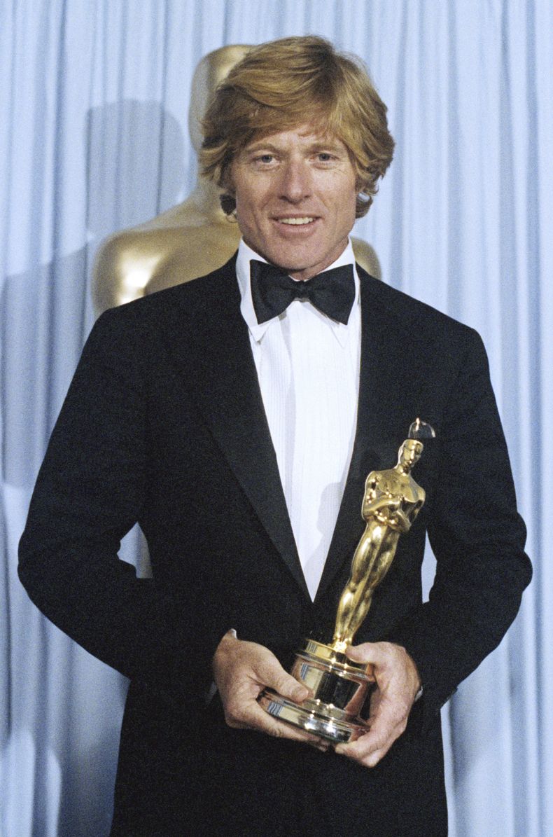 ARCHIVO - Robert Redford sostiene su Oscar de mejor dirección por Ordinary People en los Premios de la Academia en Los Ángeles el 31 de marzo de 1981. (Foto AP, archivo)