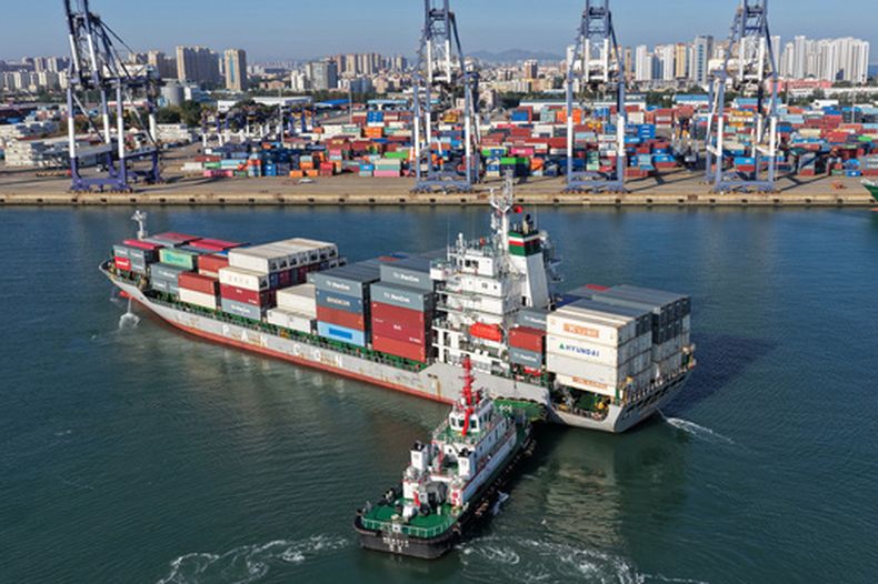 Un remolcador empuja un buque portacontenedores hacia un puerto en Yantai, en la provincia de Shandong, el 14 de octubre de 2026, en el este de China. (Chinatopix vía AP)