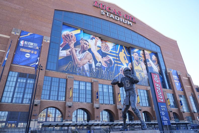 Imagen afuera del Estadio Lucas Oil con una estatua del exquarterback de los Colts de Indianápolis Peyton Manning frente al promocional por el Juego de Estrellas de la NBA el miércoles 14 de febrero del 2024. (AP Foto/Michael Conroy)