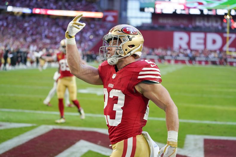 El running back de los 49ers de San Francisco Christian McCaffrey celebra luego de conseguir un touchdown en la primera mitad del partido ante los Cardinals de Arizona, el domingo 17 de diciembre de 2023, en Glendale, Arizona. (AP Foto/Matt York)