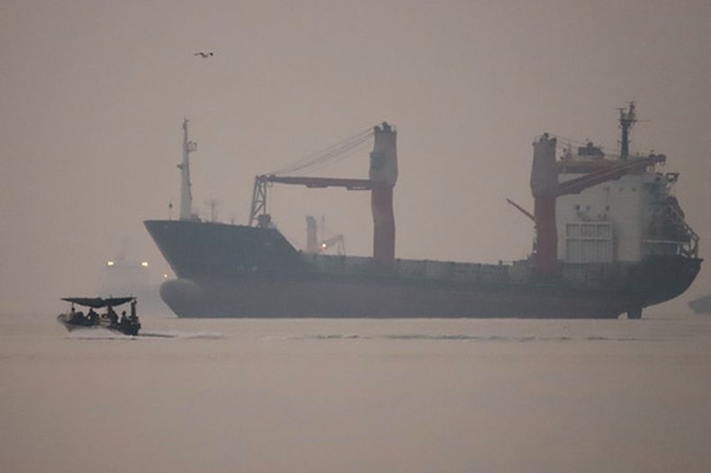 Una lancha a motor pasa junto a un buque de carga fondeado en el estrecho de Ormuz, frente a Bandar Abbas, Irán, a primera hora del lunes 28 de septiembre de 2026. (Amirhosein Khorgooi/ISNA vía AP)