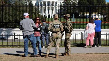 ARCHIVO – Varias personas hablan con efectivos de la Guardia Nacional en The Ellipse, con la Casa Blanca en el fondo, el 17 de octubre de 2025, en Washington. (AP Foto/Rahmat Gul, Archivo)