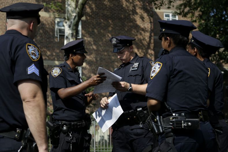 ARCHIVO- En esta foto del 13 de agosto de 2013, polic&iacute;as hacen un reporte de una mujer a la que le robaron el celular en Brownsville, una parte de Brooklyn, en Nueva York. Una corte federal de apelaciones bloque&oacute; el jueves 31 de octubre de 2