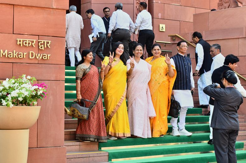 Un guardia de seguridad toma una foto de legisladoras indias ante el Parlamento antes de un debate sobre una ley histórica que reserva un tercio de los escaños a mujeres, en Nueva Delhi, India, el jueves 16 de abril de 2026. (AP Foto)