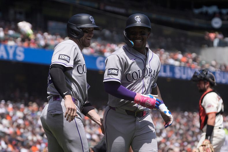 Adael Amador, de los Rockies de Colorado, (derecha), celebra tras conectar un jonrón de tres carreras con el que también anotó Brett Sullivan (izquierda) y Jordan Beck, durante la segunda entrada del juego de béisbol contra los Gigantes de San Francisco, domingo 16 de agosto de 2026, en San Francisco. (AP Foto/Jeff Chiu)