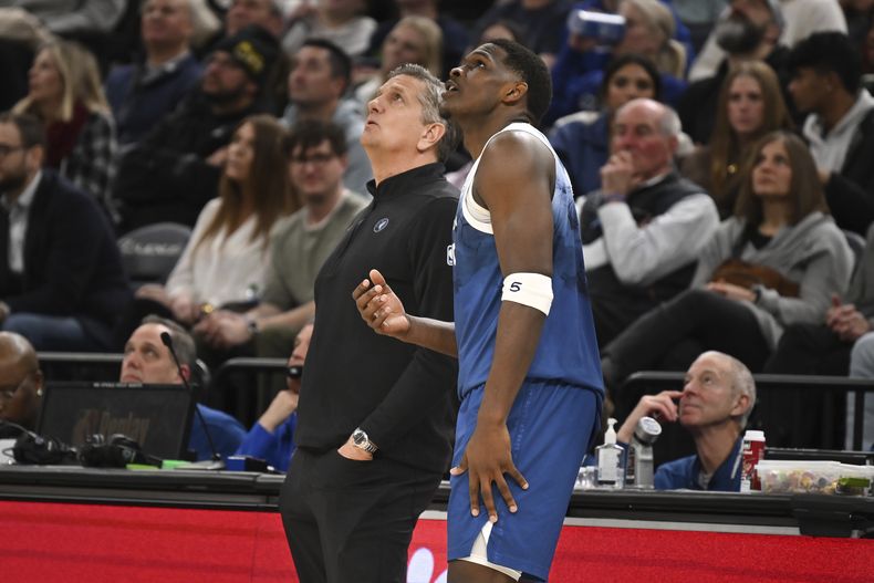 El entrenador de los Timberwolves de Minnesota Chris Finch (izquierda) y el armador Anthony Edwards observan el marcador durante una pausa de acciones en la segunda mitad ante los Grizzlies de Memphis, en el juego de baloncesto de la NBA, el miércoles 28 de febrero de 2024, en Mineápolis. (AP Foto/Craig Lassig)
