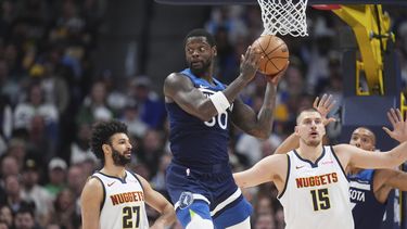 El alero de los Timberwolves de Minnesota Julius Randle intenta pasar el balón frente a Jamal Murray y Nikola Jokic de los Nuggets de Denver el miércoles 12 de marzo del 2025. (AP Foto/David Zalubowski)