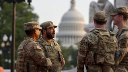 Soldados de la Guardia Nacional del Distrito de Columbia conversan en la Estación Union, con el Capitolio de Estados Unidos a sus espaldas, en Washington, el viernes 15 de agosto de 2025. (AP Foto/Alex Brandon)