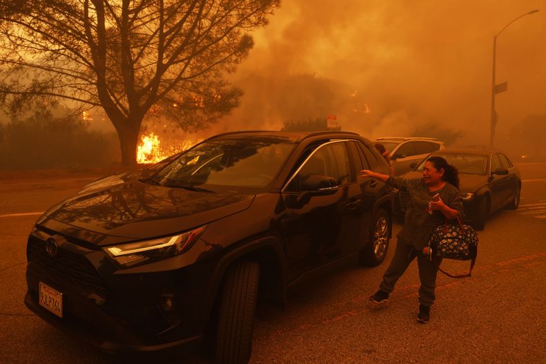 Una mujer llora mientras el incendio de Palisades avanza en el barrio de Pacific Palisades de Los Ángeles, el martes 7 de enero de 2025. (AP foto/Etienne Laurent)