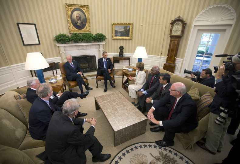 El presidente Barack Obama, al centro, y el vicepresidente Joe Biden, al centro a la izquierda, se re&uacute;nen con los l&iacute;deres dem&oacute;cratas en la Oficina Oval de la Casa Blanca, el martes 15 de octubre de 2013, en Washington. Sentados con el