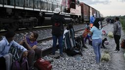 Migrantes observan un tren en marcha junto a las vías en las que esperan para subir a bordo de un vagón con el fin de dirigirse al norte de México, el 19 de septiembre de 2023, en Huehuetoca, México. (AP Foto/Eduardo Verdugo)