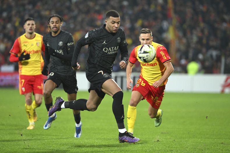 El delantero Kylian Mbappe controla el balón durante el partido contra Lens en la liga francesa, el domingo 14 de enero de 2024, en Lens. (AP Foto/Matthieu Mirville)