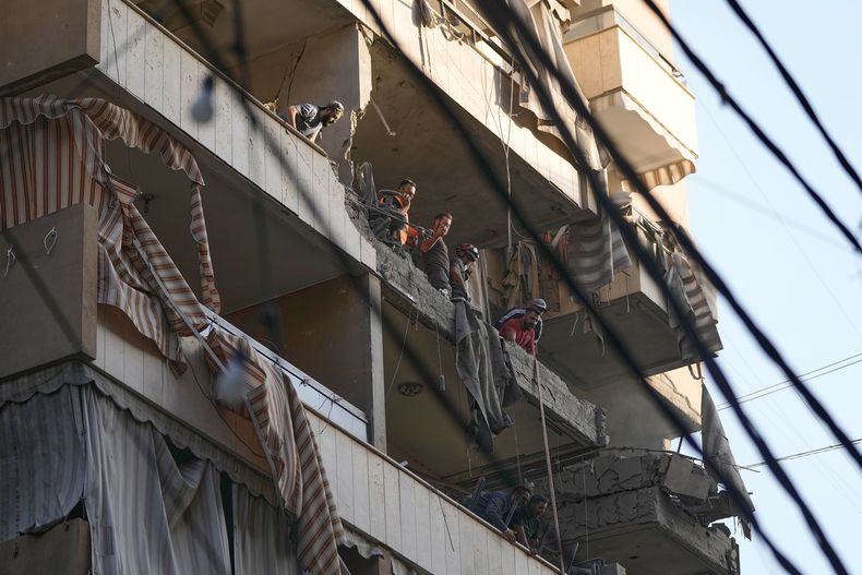 Personal de la Defensa Civil libanesa inspecciona los daños en un apartamento impactado durante un ataque aéreo israelí en Dahiyeh, en el suburbio sur de Beirut, el domingo 23 de noviembre de 2025. (Foto AP/Bilal Hussein)