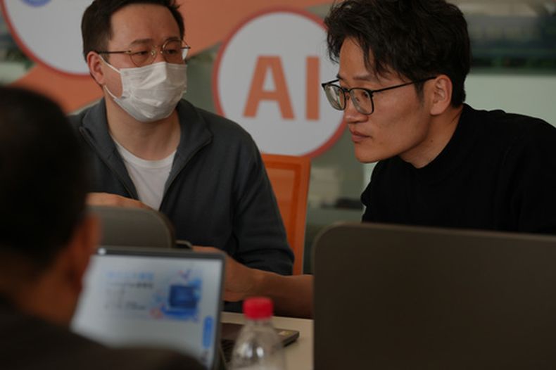 Varias personas instalan el software RedClaw AI en sus laptops, en Beijing, el 22 de marzo de 2026. (AP Foto/Andy Wong)