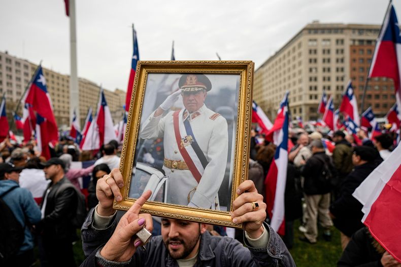 ARCHIVO - Un grupo de simpatizantes del general Augusto Pinochet celebra el 50 aniversario del golpe de Estado que él encabezó, cerca del palacio presidencial de La Moneda, el 9 de septiembre de 2023, en Santiago, Chile. (AP Foto/Esteban Félix, archivo)
