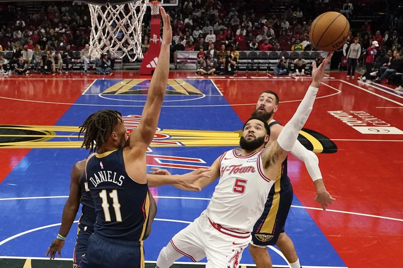 El armador de los Rockets de Houston Fred VanVleet (5) tira mientras defiende el base de lo Pelicans de Nueva Orleans (11) durante la 2da mitad del juego del torneo de temporada de la NBA, el viernes 10 de noviembre de 2023, en Houston. (AP Foto/Eric Christian Smith)