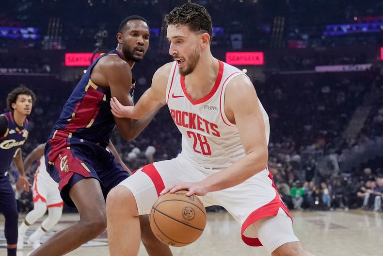 El pívot de los Rockets de Houston Alperen Sengun avanza hacia la canasta frente al pívot de los Cavaliers de Cleveland Evan Mobley en el encuentro del miércoles 19 de noviembre del 2025. (AP Foto/Sue Ogrocki)