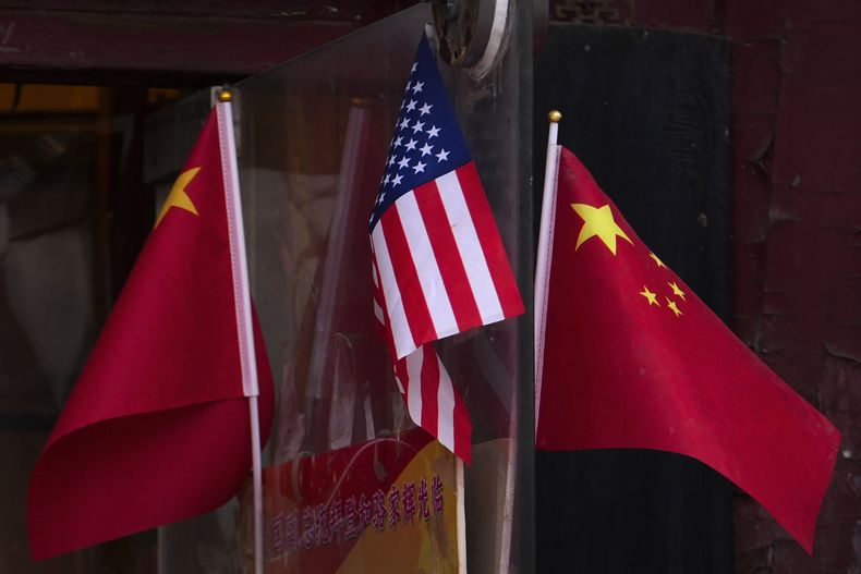 Banderas de China y Estados Unidos ondean afuera de una tienda de recuerdos el 31 de enero de 2025, en Beijing. (AP Foto/Andy Wong)