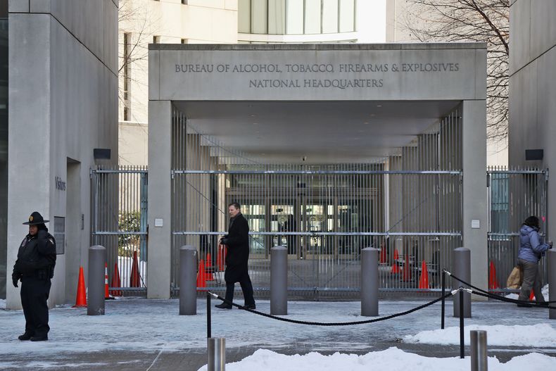 Un agente de seguridad camina frente a la entrada de la oficina central de la Agencia de Alcohol, Tabaco, Armas de Fuego y Explosivos de Estados Unidos, el 23 de enero de 2014, en Washington. (AP Foto/Charles Dharapak, Archivo)