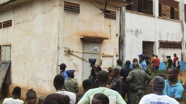 Un grupo de personas se congrega en el lugar donde se registró una explosión que provocó una estampida, incidentes en que murieron decenas de estudiantes y cientos de ellos resultaron heridos, en una escuela secundaria en Bangui, la capital de la República Centroafricana, el jueves 26 de junio de 2025. (AP Foto/Jean Fernand Koena)