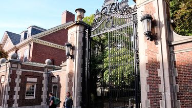 Dos mujeres atraviesan una puerta en el jardín Harvard de la universidad del mismo nombre, el martes 30 de septiembre de 2025, en Cambridge, Massachusetts. (AP Photo/Charles Krupa)