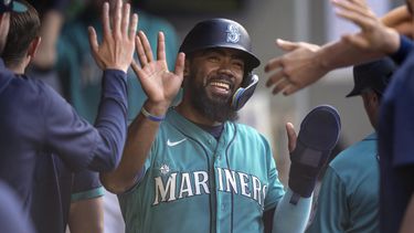 Teoscar Hernandez felicitado por sus compañeros de los Marineros de Seattle en el dugout tras anotar con el sencillo de Jarred Kelenic en el encuentro ante los Rays de Tampa Bay el sábado 1 de julio del 2023. (AP Foto/Stephen Brashear)