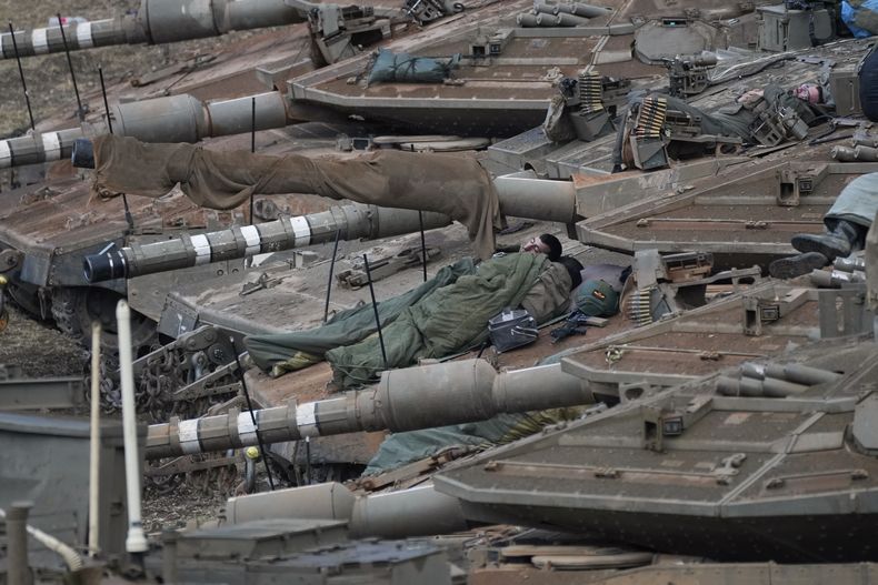 Soldados israelíes duermen en tanques en una zona de preparación en el norte de Israel, cerca de la frontera con Líbano, el martes 1 de octubre de 2024. (AP Foto/Baz Ratner)