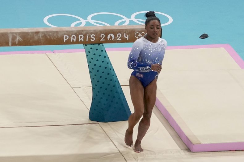 Simone Biles, de Estados Unidos, cae de la viga durante la final de la barra de equilibrio individual de gimnasia artística femenina en el Bercy Arena en los Juegos Olímpicos de Verano de 2024, el lunes 5 de agosto de 2024, en París, Francia. (AP Foto/Morry Gash)