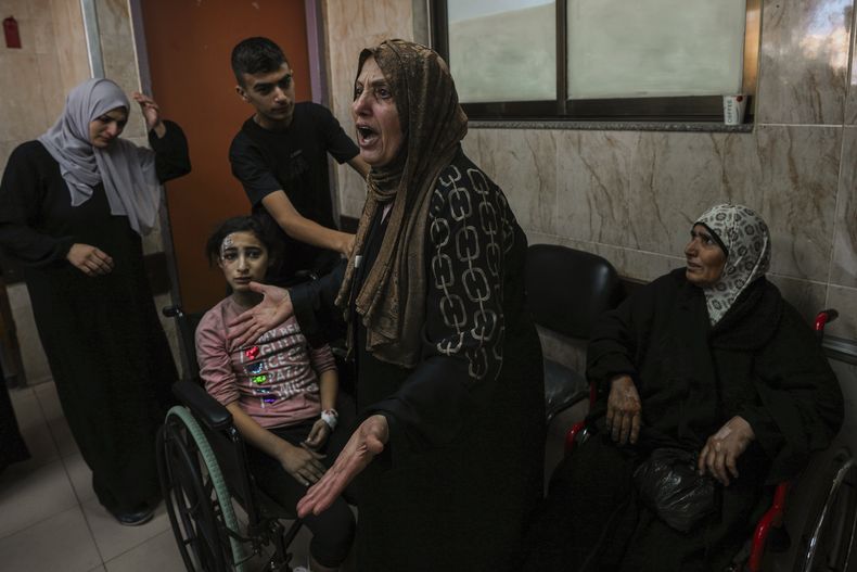 Una mujer palestina reacciona junto a varios heridos en el hospital Al-Aqsa de Deir el-Balah, en el centro de la Franja de Gaza, el domingo 15 de octubre de 2023. (AP Foto/Adel Hana)
