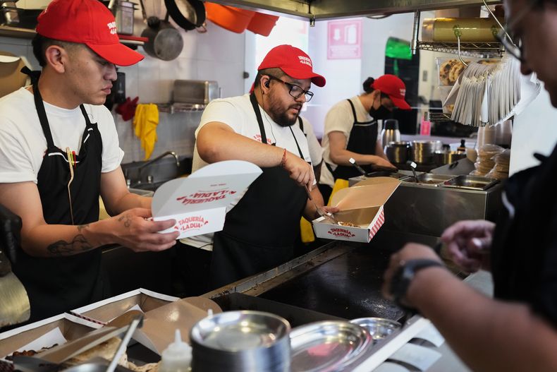 Trabajadores preparan tacos en la inauguración de la taquería La Dua de Dua Lipa, un restaurante temporal para sus fans en la Ciudad de México, el lunes 1 de diciembre de 2025. (Foto AP/Eduardo Verdugo)