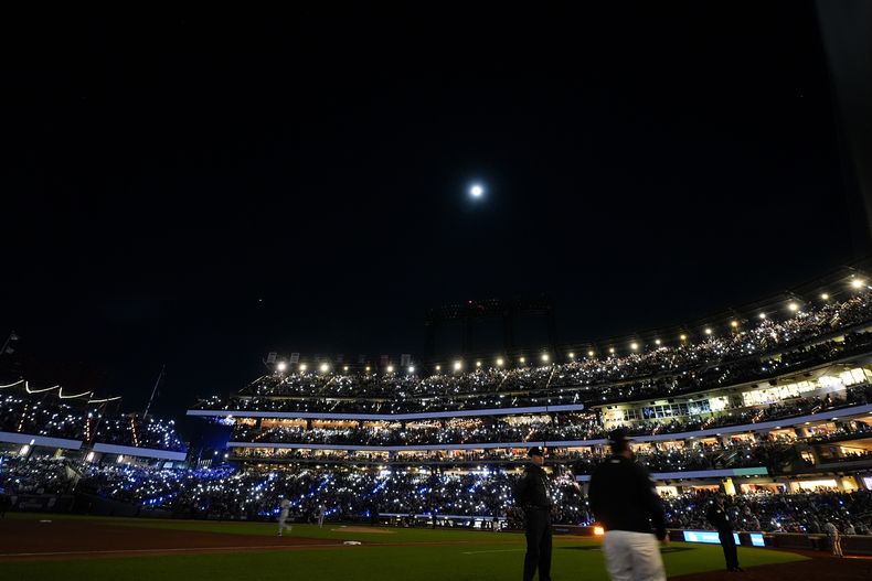Aficionados encienden las luces LED en el estadio durante la tercera entrada del tercer juego de la Serie de Campeonato de la Liga Nacional ante los Dodgers de Los Ángeles el miércoles 16 de octubre del 2024. (AP Foto/Frank Franklin II)